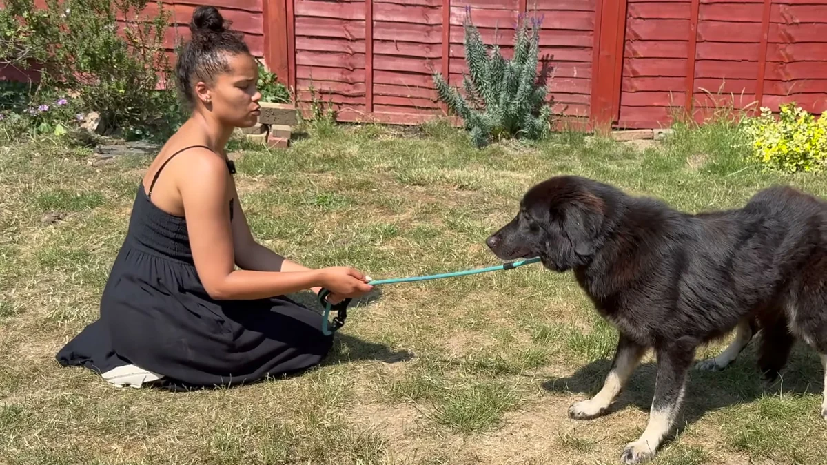 Ella kneeling face to face with Amara on the grass