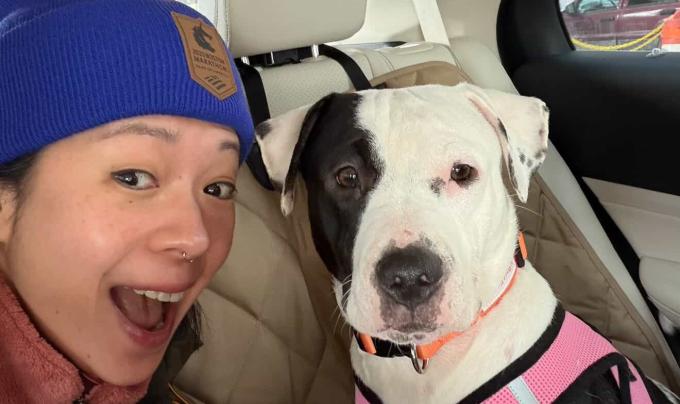 Maggie, a deaf dog adopted from Best Friends Animal Society NYC, sitting with her new mom Heather in a vehicle on adoption day